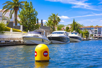 The building with palm trees by the water and motor boats