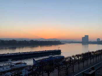 High angle view of river by buildings against sky during sunset