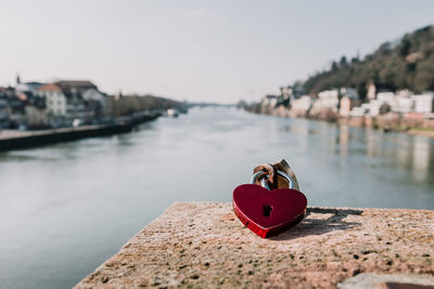 Heart shape padlock at riverbank in city