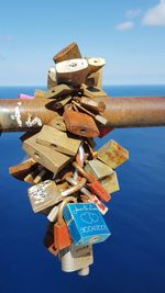 Close-up of padlocks on rusty metal against sea