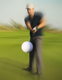 Blurred motion of man on golf ball