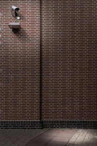 Security camera on brick wall of building