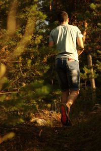 Rear view of man walking in forest