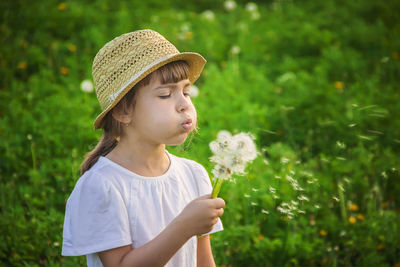 Portrait of young woman standing against plants