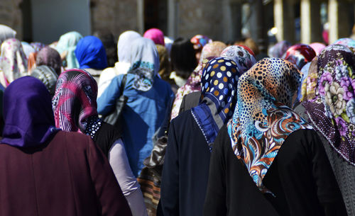 Rear view of people walking in row