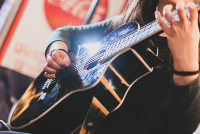 Midsection of man playing guitar