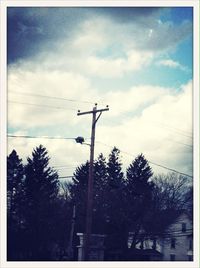 Low angle view of bare tree against cloudy sky