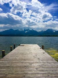 Wooden pier over lake against sky