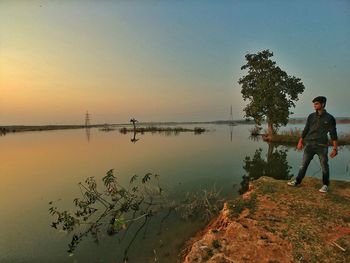 Scenic view of lake against clear sky at sunset