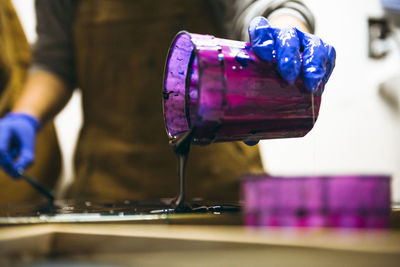 Female resin artist pouring blue resin tint