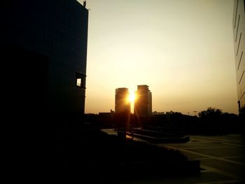 Silhouette of city against clear sky during sunset