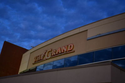 Low angle view of information sign against blue sky