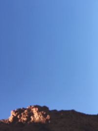 Low angle view of mountain against clear blue sky