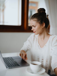 Young woman using laptop at home