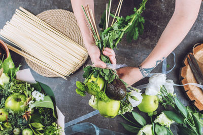 High angle view of hand holding vegetables in basket