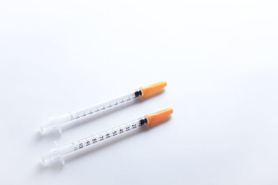 A pair of insulin syringes on white background.