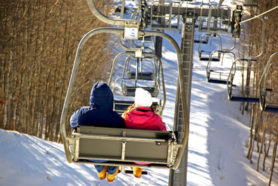 Rear view of people sitting in snow