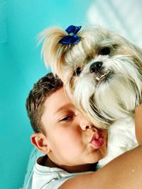 Portrait of boy puckering while embracing dog