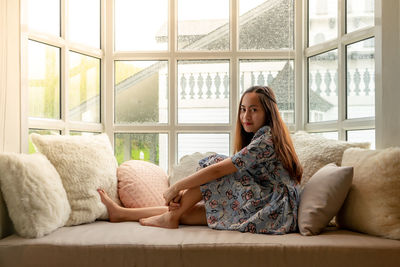 Portrait of woman sitting on sofa at home