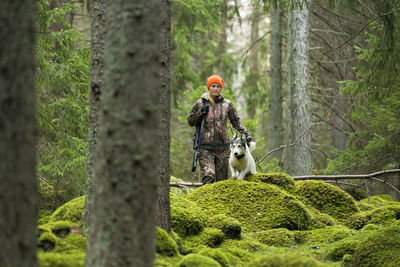 Woman with hunting dog in forest