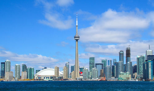 City at waterfront against cloudy sky