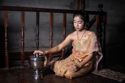 Girl in traditional clothing sitting at home