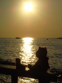 Silhouette people on beach against sky during sunset