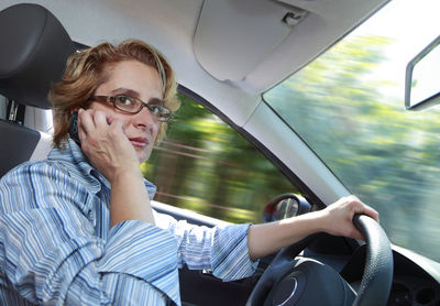 Woman using mobile phone while driving car