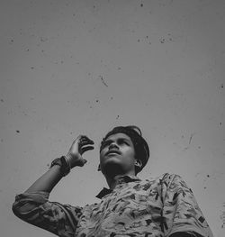 Low angle view of woman looking up against wall