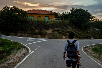 Rear view of man standing on road