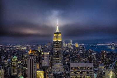 Illuminated cityscape against sky at night