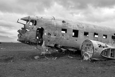 Abandoned airplane on land against sky