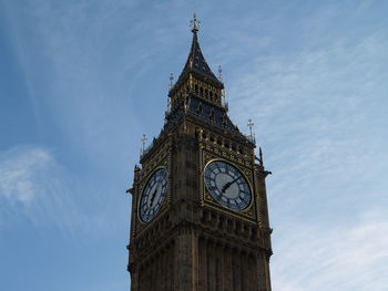 Low angle view of clock tower against cloudy sky