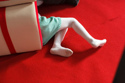 Low section of girl relaxing on red floor