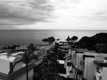 High angle view of townscape by sea against sky