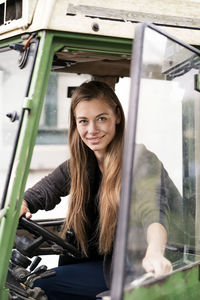 Portrait of smiling woman driving a tractor