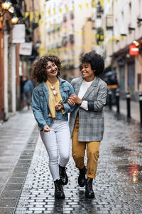 Women walking on street in rain