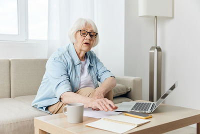 Young woman using laptop at home