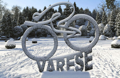 Snow covered sculpture on field against sky