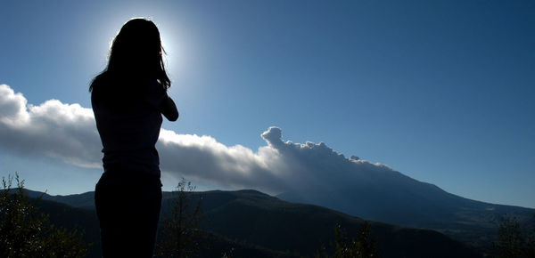Silhouette woman standing on mountain against sky