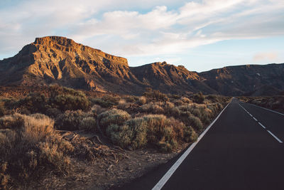 Road by mountain against sky