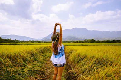 Rear view of woman standing on field
