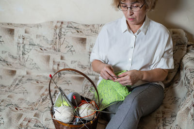 Midsection of woman sitting at home