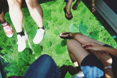 Low section of people sitting on tiled floor