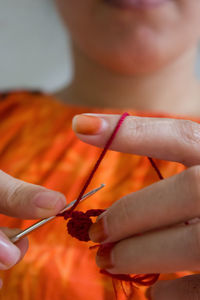 Midsection of woman knitting wool