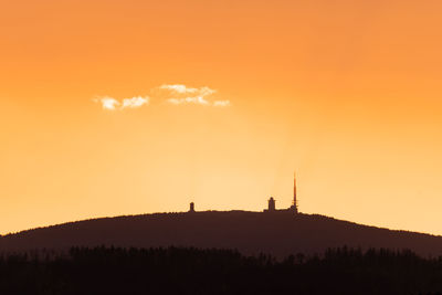 Scenic view of silhouette landscape against orange sky