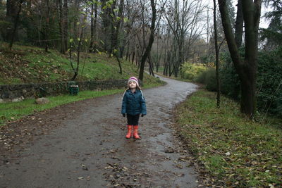 Full length of woman walking on road in forest