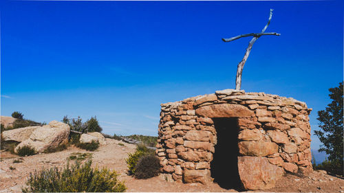 Low angle view of rock formation against clear blue sky