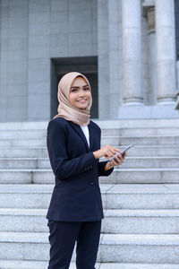 Woman using mobile phone in city