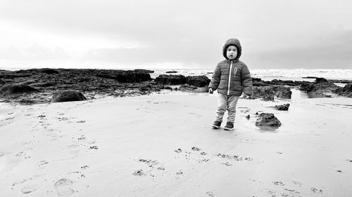 Portrait of toddler child on beach against sky